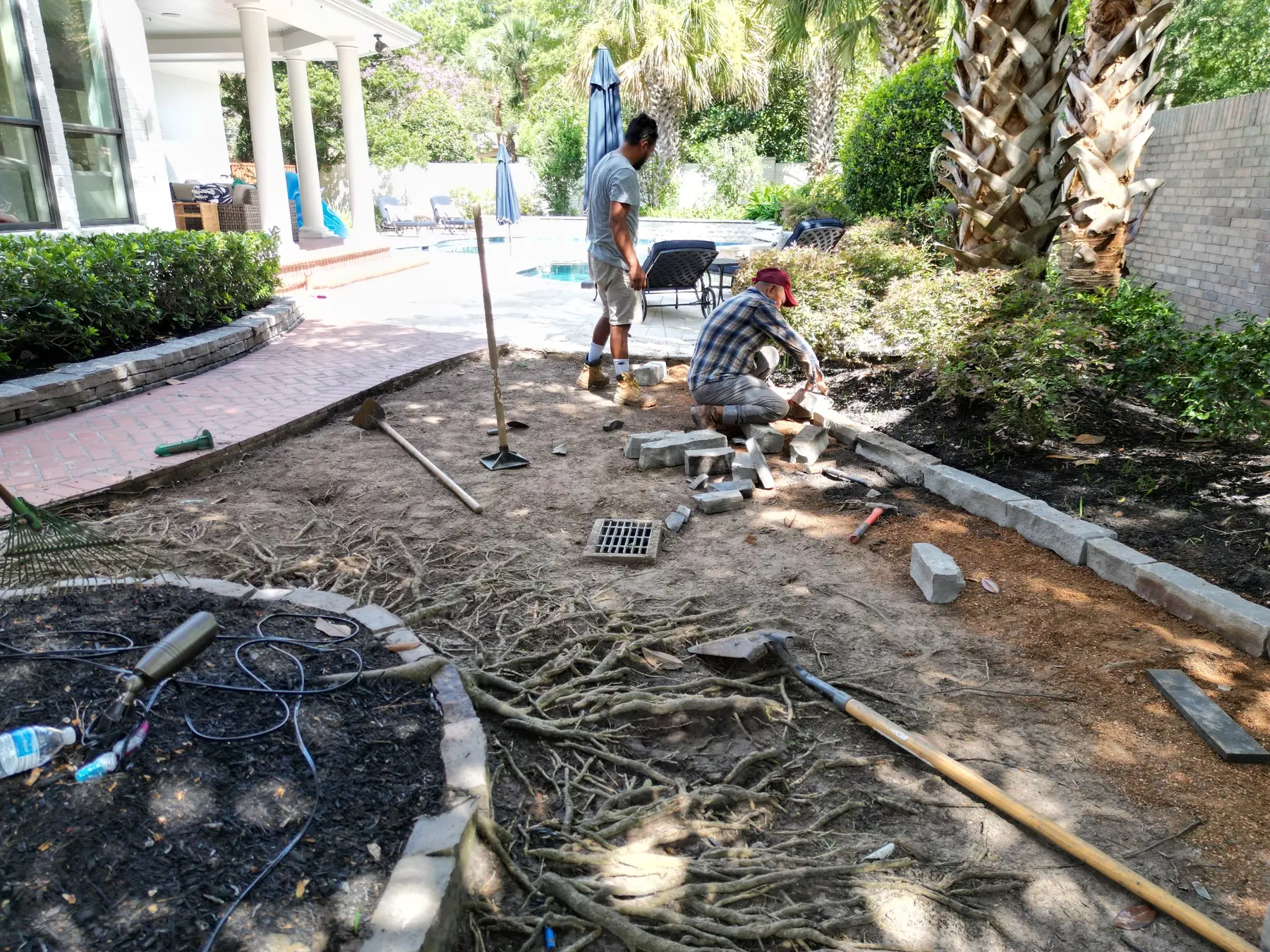 Artificial Grass TX crew preparing curved borders around mature trees before turf installation