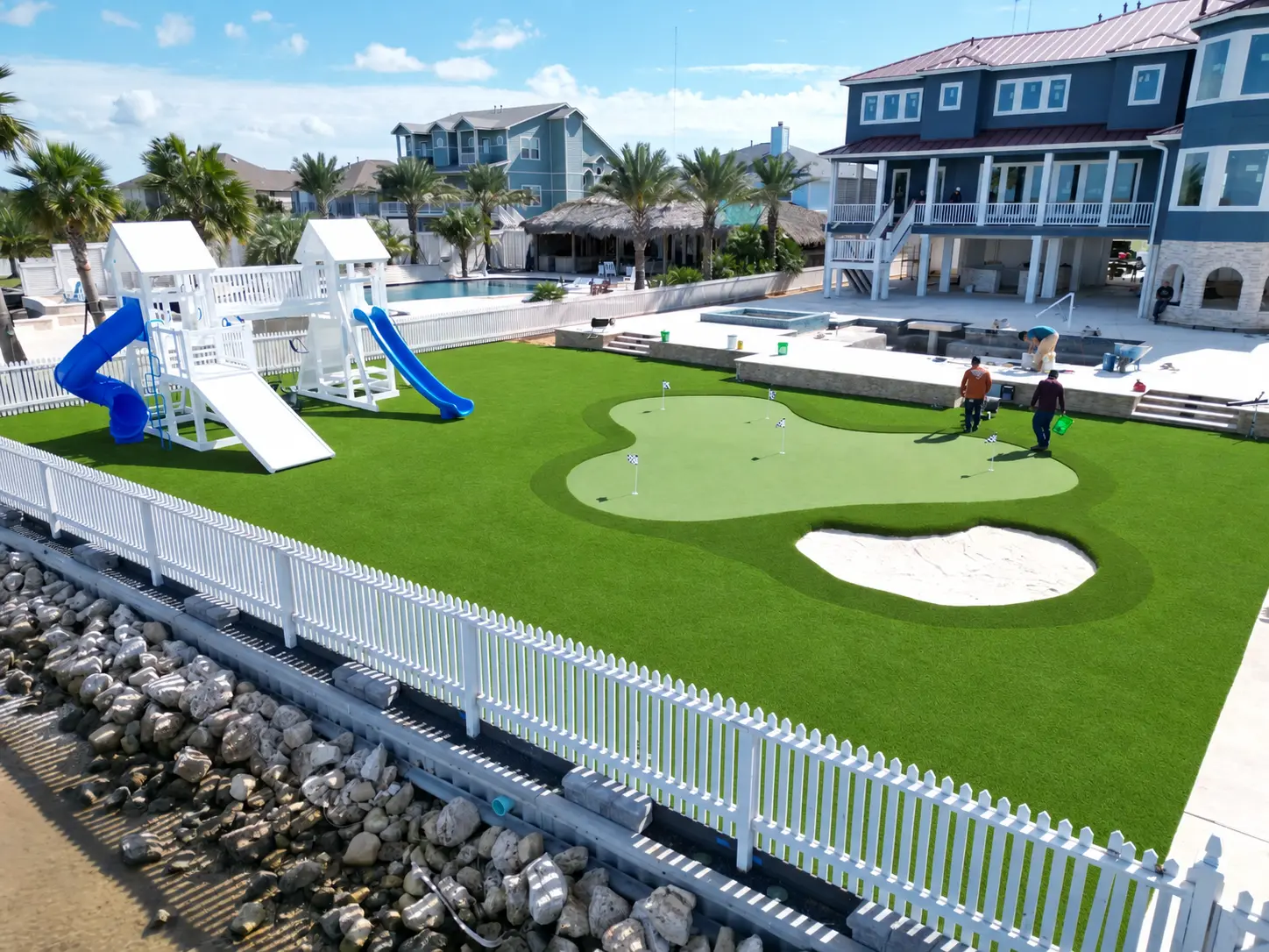 Completed waterfront artificial turf project with putting green, playground and pool