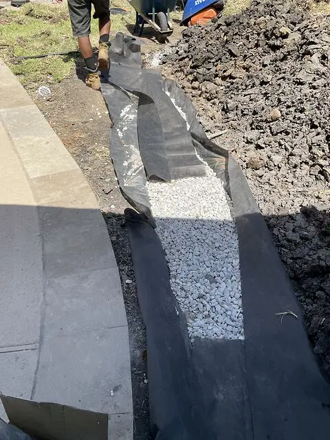 Filter fabric and drainage stone installed beneath artificial grass