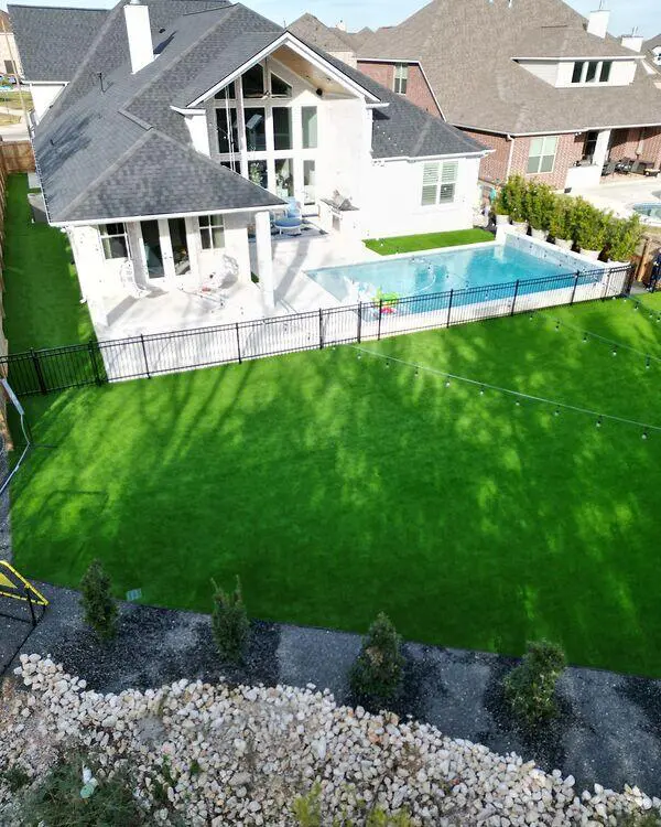 Backyard artificial grass installation beside a residential swimming pool