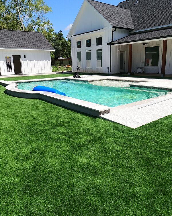 Poolside artificial grass installed around a residential swimming pool
